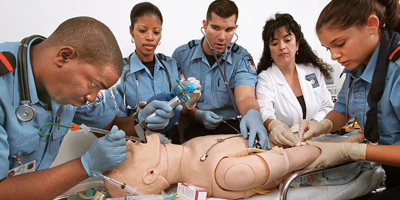 EMS students gather around a dummy