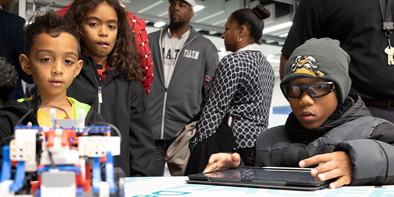 Children use a remote controlled robot