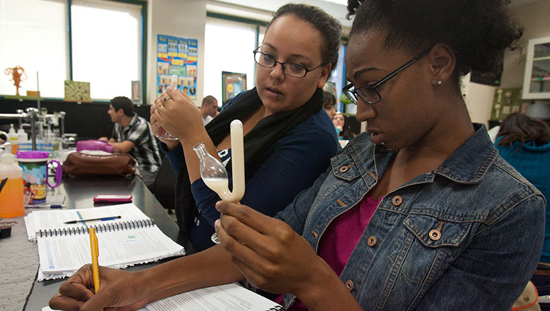 Two students hold up phials in science class