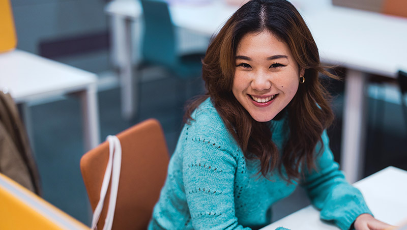 A high school student smiles at the camera