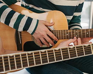 Close-up of person playing an acoustic guitar