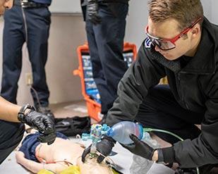 A paramedic student goes through a simulation of assiting a child patient