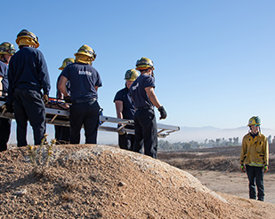 Student trainees maneuver with a litter