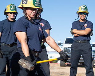 A trainee holds a sledge hammer during a training exercise