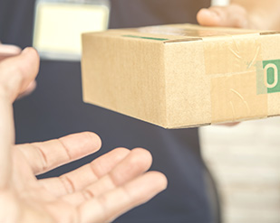 Closeup of a shipping box being handed to someone
