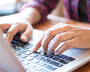 Closeup of a person typing on a laptop