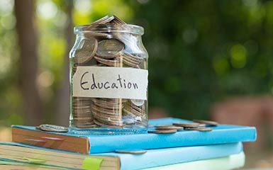 Savings jar of coins on top of books