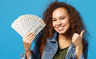 A student holds up financial aid money