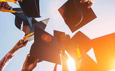 Graduates throw their caps