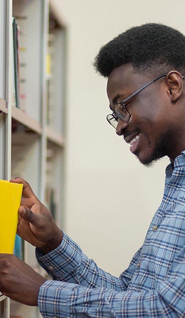 A male student browses books in the library