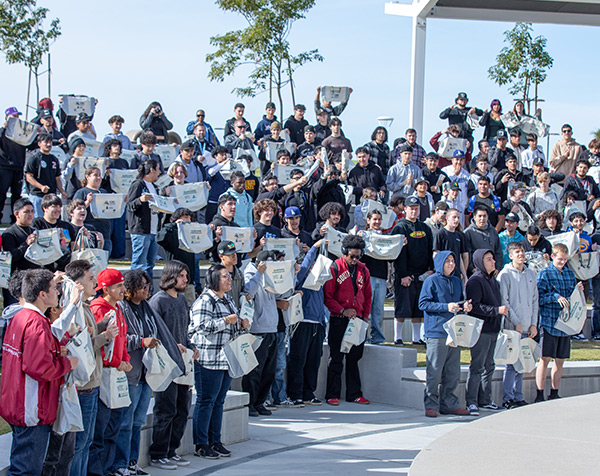 A large group of expo attendees stand in the outdoor amphiteatre