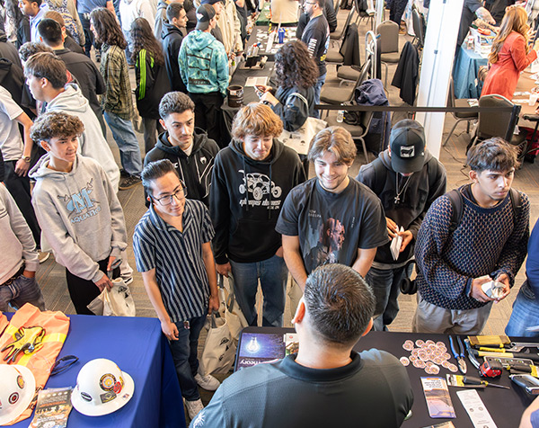 Top down view of part of the crowd speaking to tradesmen