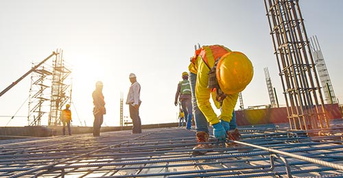 A construction worker lays rebar reinforcement at a job site