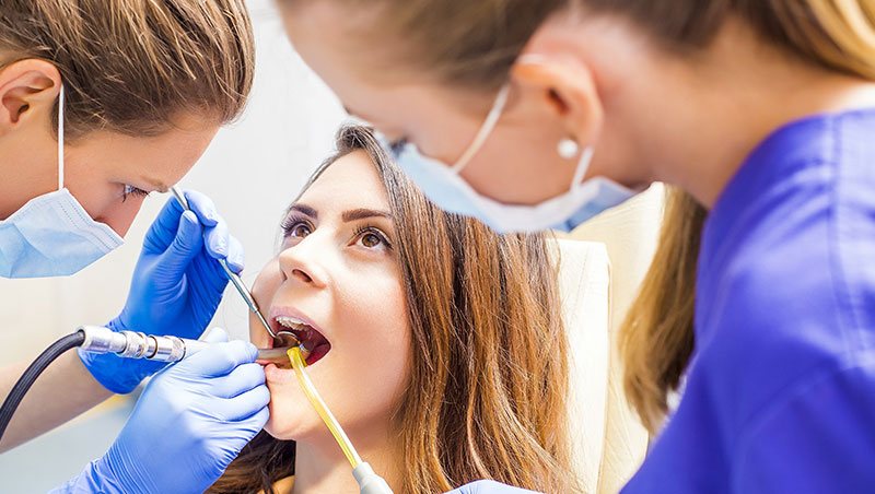 Dental hygiene students work on patient