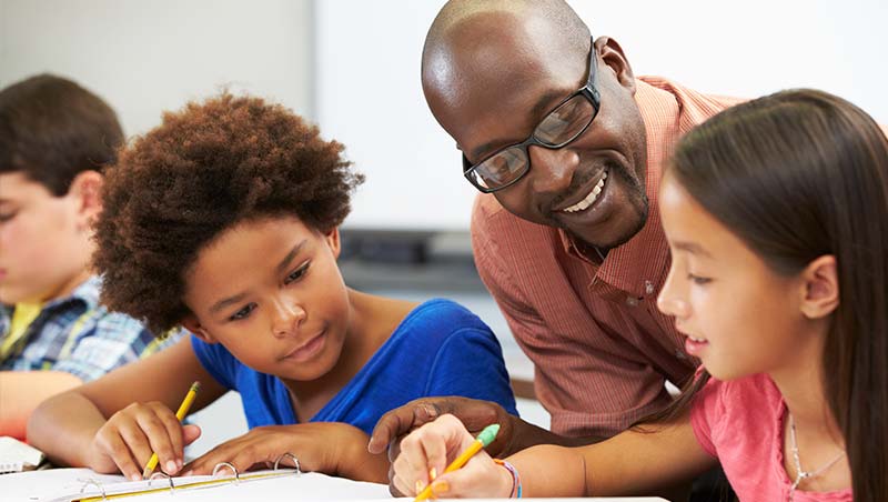 A teacher works with a young student