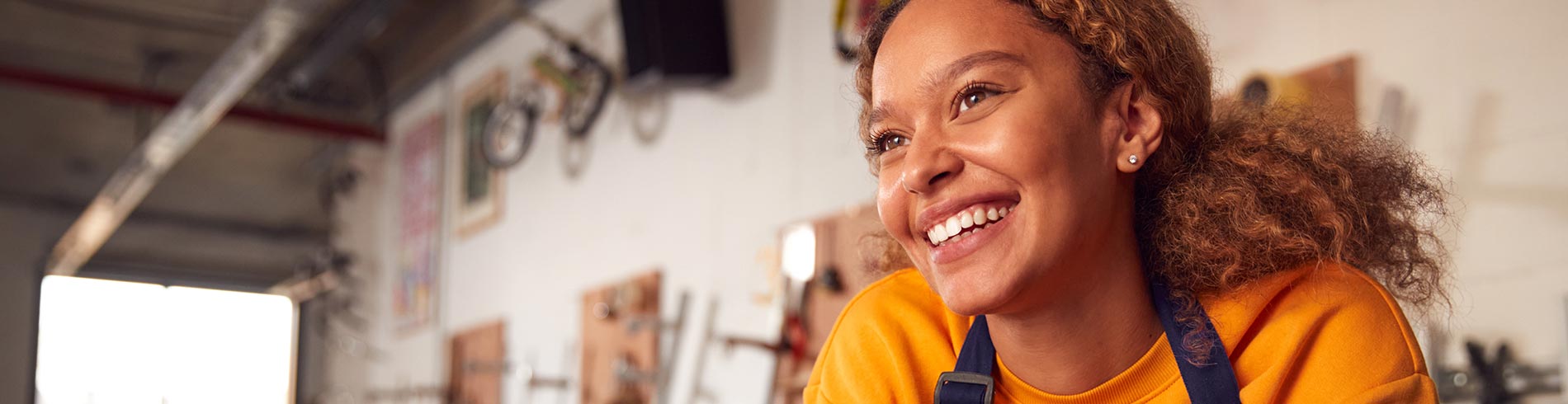 Young woman smiles while working on a tablet in a small business