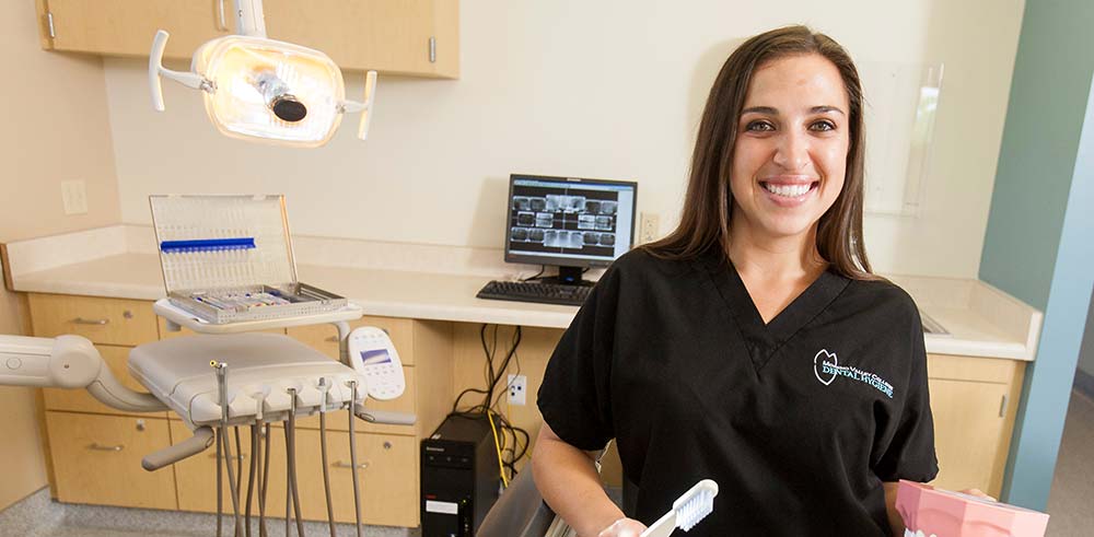 Dental hygiene student stands in clinic