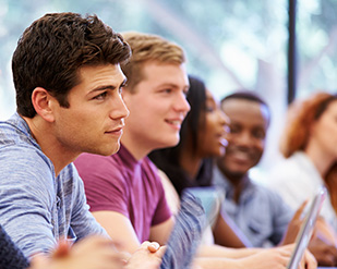 A row of students sit during a lecture