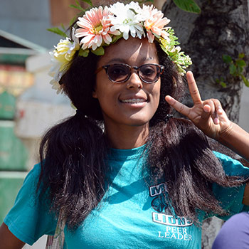 An MVC student flashes a peace sign at the camera while wearing a flower crown