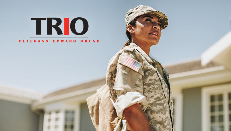 A veteran woman wearing fatigues looks off into the distance on a sunny day