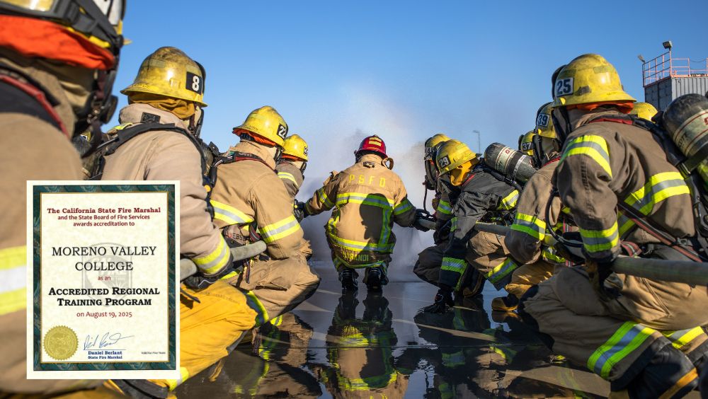 Photo of fire academy cadets in PPE crouching on wet ground during a live exercise