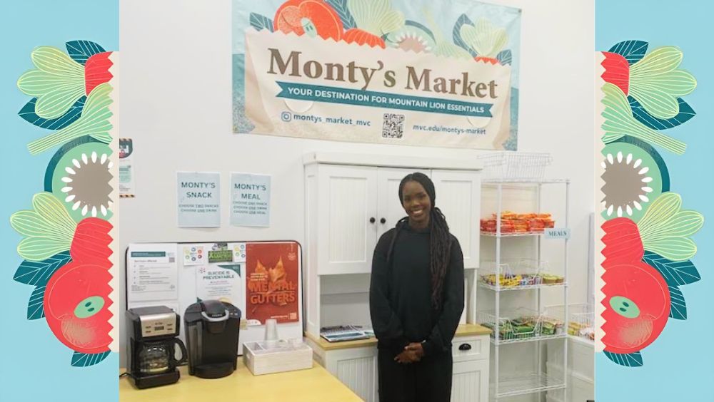 A student stands in front of a small free food and essentials pantry stand