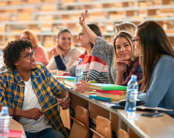 A group of students study and socialize in a university auditorium-style classroom