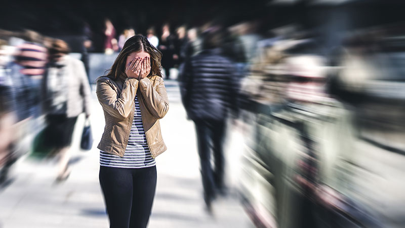 A young woman has a panic attack in public