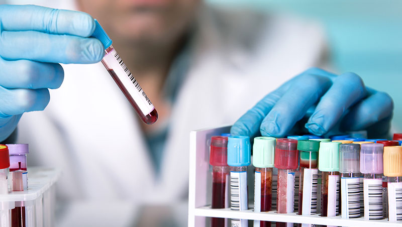 A technician holds up test vials