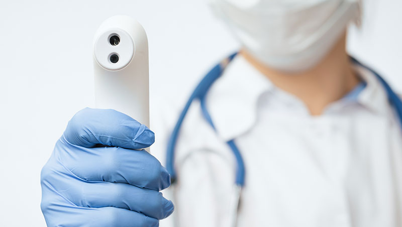 Nurse holds up thermometer