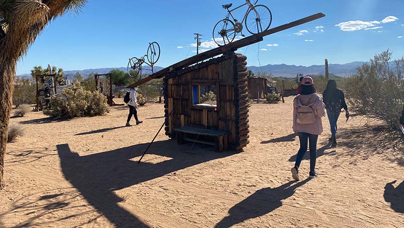 Students explore Joshua Tree National Park and walk by wooden structures