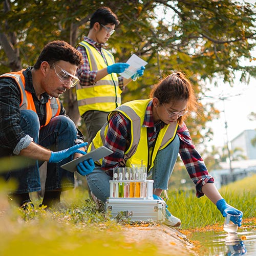 Three young environmental scientists collect samples