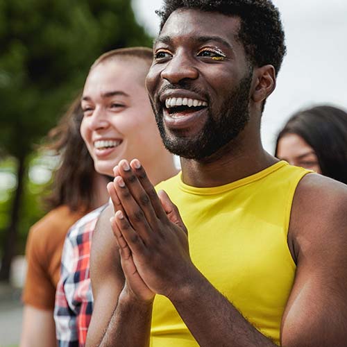 A smiling young man grins at his friends