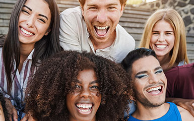 A diverse group of students smile and laugh