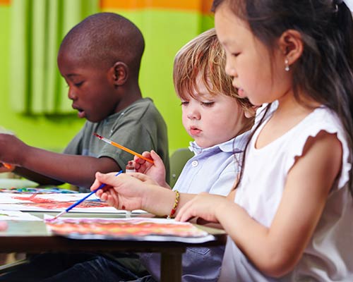 Three children color and draw