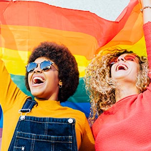 Two students wave a pride flag