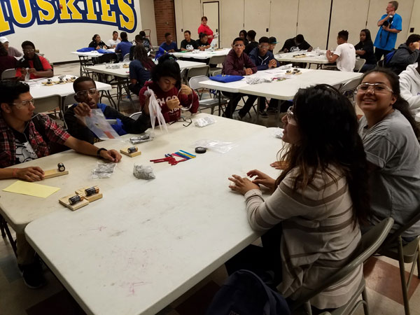 Students gather around a table during a science activity